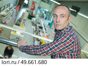 man looking at a factory from upstairs. Стоковое фото, агентство Ingram Publishing / Фотобанк Лори