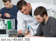 electronic assembler using a soldering iron. Стоковое фото, агентство Ingram Publishing / Фотобанк Лори