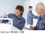 supervisor assessing young woman painting. Стоковое фото, агентство Ingram Publishing / Фотобанк Лори