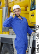 busy dockworker using the phone with cargo transportation. Стоковое фото, агентство Ingram Publishing / Фотобанк Лори