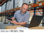 man in warehouse holding scanner and looking at laptop. Стоковое фото, агентство Ingram Publishing / Фотобанк Лори