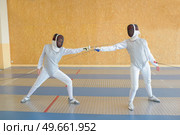 Two people in fencing combat. Стоковое фото, агентство Ingram Publishing / Фотобанк Лори