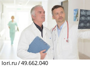 doctors examining the patient's examination result. Стоковое фото, агентство Ingram Publishing / Фотобанк Лори