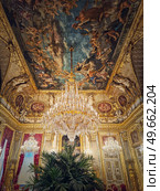 Beautiful decorated Napoleon apartments at Louvre palace. Royal family rooms with cardinal red curtains, golden ornate walls, paintings and crystal chandeliers suspended from ceiling. Стоковое фото, агентство Ingram Publishing / Фотобанк Лори