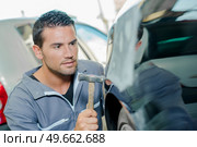 male worker is tapping the car. Стоковое фото, агентство Ingram Publishing / Фотобанк Лори