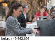 woman playing on an old piano in street cafe. Стоковое фото, агентство Ingram Publishing / Фотобанк Лори