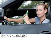 a female driver drinking beer. Стоковое фото, агентство Ingram Publishing / Фотобанк Лори