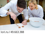 trainee confectioner preparing chocolate squares. Стоковое фото, агентство Ingram Publishing / Фотобанк Лори