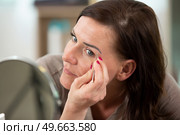 beautiful girl correcting eyebrows with tweezers. Стоковое фото, агентство Ingram Publishing / Фотобанк Лори