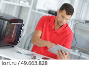handsome repairer gathering informations on internet. Стоковое фото, агентство Ingram Publishing / Фотобанк Лори