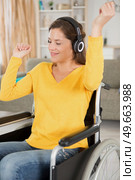 woman in wheelchair wearing headphones and dancing to the music. Стоковое фото, агентство Ingram Publishing / Фотобанк Лори