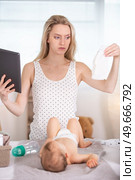parent learning to changing newborns diapers. Стоковое фото, агентство Ingram Publishing / Фотобанк Лори