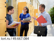 man showing young couple the locker room. Стоковое фото, агентство Ingram Publishing / Фотобанк Лори