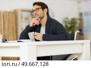 handsome disable man thinking at home. Стоковое фото, агентство Ingram Publishing / Фотобанк Лори