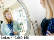 Lady wearing scarf looking at reflection in mirror. Стоковое фото, агентство Ingram Publishing / Фотобанк Лори