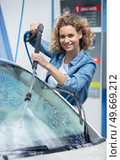 young woman cleaning her car in a self service. Стоковое фото, агентство Ingram Publishing / Фотобанк Лори