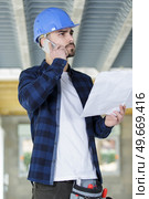 contractor on site holding plans and making telephone call. Стоковое фото, агентство Ingram Publishing / Фотобанк Лори