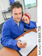 a plumber is ordering parts. Стоковое фото, агентство Ingram Publishing / Фотобанк Лори