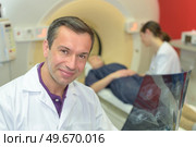 Portrait of doctor by scanning machine. Стоковое фото, агентство Ingram Publishing / Фотобанк Лори