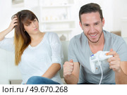 Chilling out at home with a games console. Стоковое фото, агентство Ingram Publishing / Фотобанк Лори