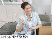 beautiful female sitting on floor with sampler and paint brush. Стоковое фото, агентство Ingram Publishing / Фотобанк Лори
