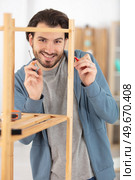 the young man tries himself to assemble furniture. Стоковое фото, агентство Ingram Publishing / Фотобанк Лори