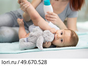 adorable baby layed on the floor chewing teddy. Стоковое фото, агентство Ingram Publishing / Фотобанк Лори