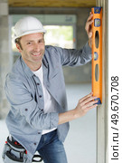 happy builder using a level n. Стоковое фото, агентство Ingram Publishing / Фотобанк Лори