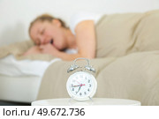 young woman on white bed yawn awakening with alarm clock. Стоковое фото, агентство Ingram Publishing / Фотобанк Лори