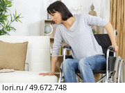 woman transferring from wheelchair to sofa. Стоковое фото, агентство Ingram Publishing / Фотобанк Лори