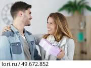 pretty woman surprising her boyfriend with gift. Стоковое фото, агентство Ingram Publishing / Фотобанк Лори