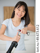portrait of a young woman opening wine bottle. Стоковое фото, агентство Ingram Publishing / Фотобанк Лори