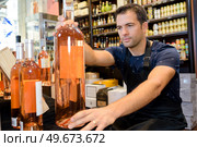 restocking bottles in liquor store. Стоковое фото, агентство Ingram Publishing / Фотобанк Лори