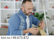 man measuring wood piece for furniture assembling. Стоковое фото, агентство Ingram Publishing / Фотобанк Лори