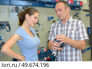 a couple is choosing handheld driller. Стоковое фото, агентство Ingram Publishing / Фотобанк Лори