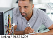 a man is examining a pc. Стоковое фото, агентство Ingram Publishing / Фотобанк Лори