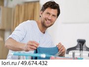 man doing drying cloths at home. Стоковое фото, агентство Ingram Publishing / Фотобанк Лори