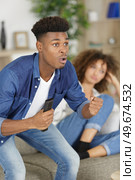 wife unhappy that husband is watching football. Стоковое фото, агентство Ingram Publishing / Фотобанк Лори