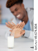 man refusing glass of milk at home. Стоковое фото, агентство Ingram Publishing / Фотобанк Лори
