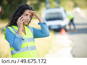 broken down woman wears reflective vest while phoning for assistance. Стоковое фото, агентство Ingram Publishing / Фотобанк Лори