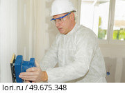 mature contractor sanding wall. Стоковое фото, агентство Ingram Publishing / Фотобанк Лори