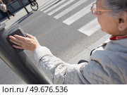 elderly woman pressing crosswalk button. Стоковое фото, агентство Ingram Publishing / Фотобанк Лори