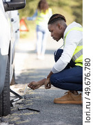 close-up of a worried man looking at punctured car tire. Стоковое фото, агентство Ingram Publishing / Фотобанк Лори