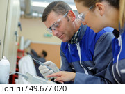 man and woman in uniform working with technical objet. Стоковое фото, агентство Ingram Publishing / Фотобанк Лори