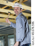 man hammers a nail with a hammer. Стоковое фото, агентство Ingram Publishing / Фотобанк Лори
