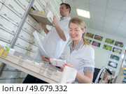 junior pharmacist taking medicine from shelf in the pharmacy. Стоковое фото, агентство Ingram Publishing / Фотобанк Лори