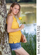 portrait of lovely lady looking at flower and smelling it. Стоковое фото, агентство Ingram Publishing / Фотобанк Лори