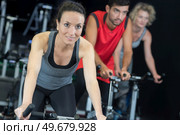 people training on the exercise bikes together. Стоковое фото, агентство Ingram Publishing / Фотобанк Лори