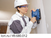 female construction worker smoothing wall surface. Стоковое фото, агентство Ingram Publishing / Фотобанк Лори