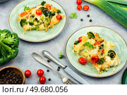 Potato casserole or gratin with broccoli and tomatoes on a plate. French cuisine. Potato Casserole with Broccoli and Tomatoes. Стоковое фото, агентство Ingram Publishing / Фотобанк Лори